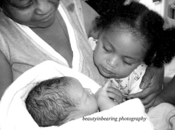 Doula support of extended famli, Grandma cuddling big sister and newborn baby brother.